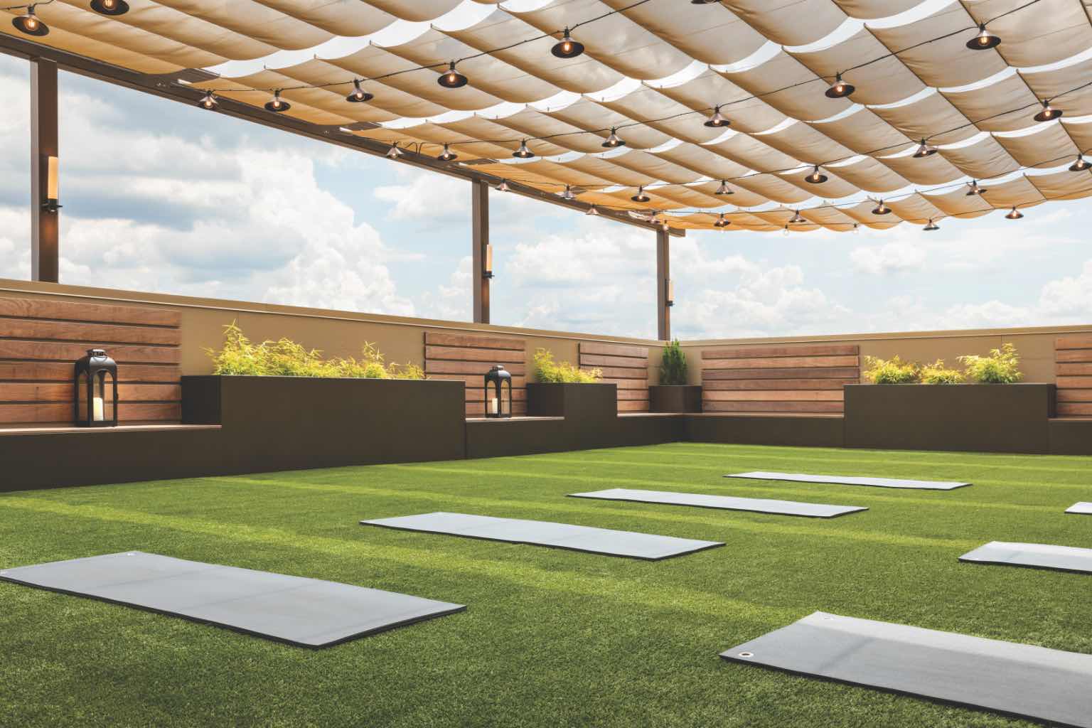 Image of outdoor patio area, with greenery and yoga mats laid out. 