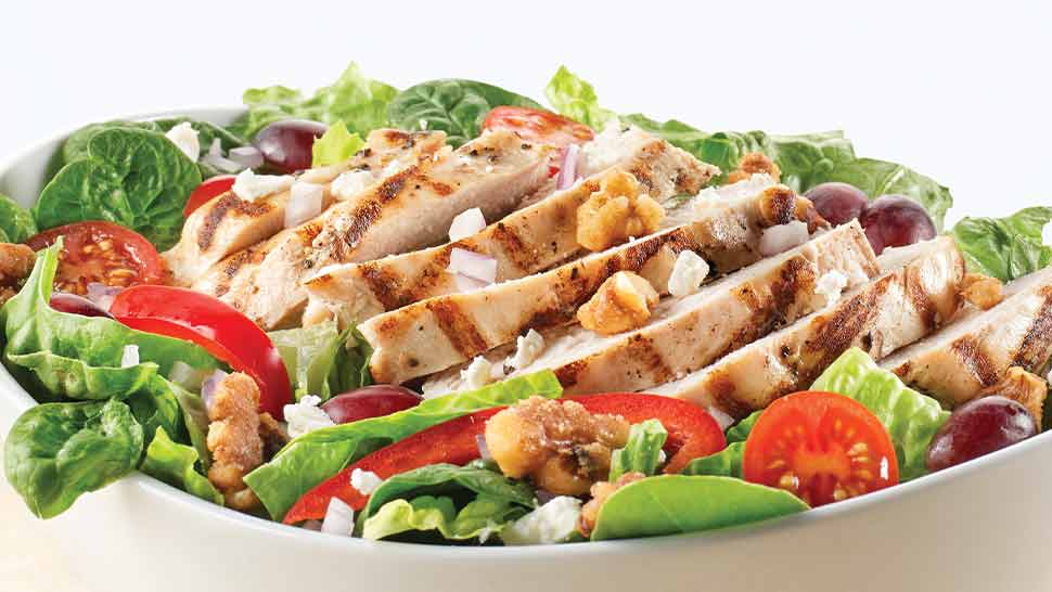 Mixed green salad with cherry tomatoes and grilled chicken in a bowl